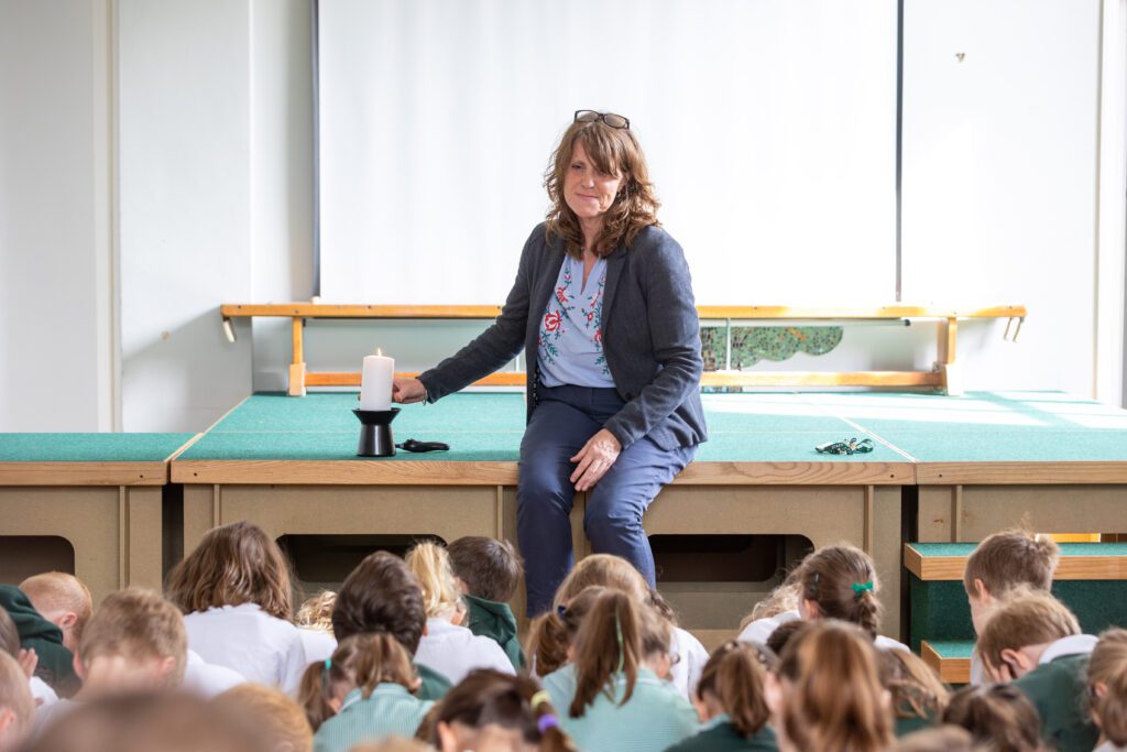 headteacher leading collective worship in the school hall
