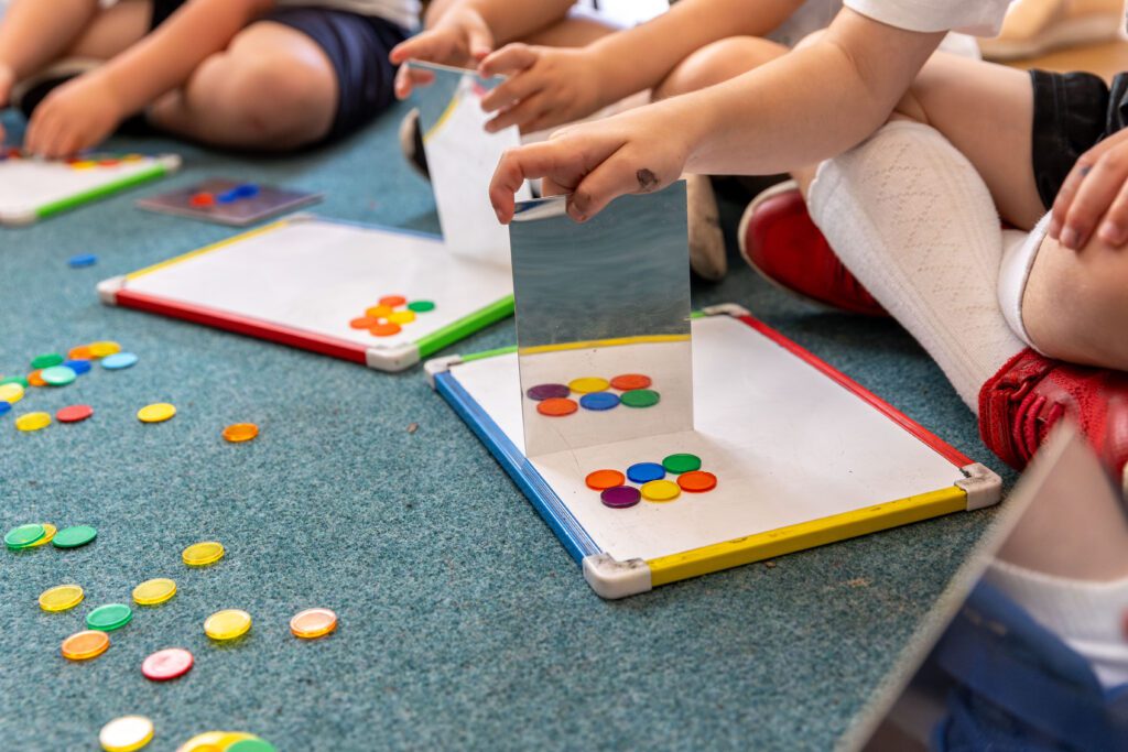 children using mirrors to explore symmetry 